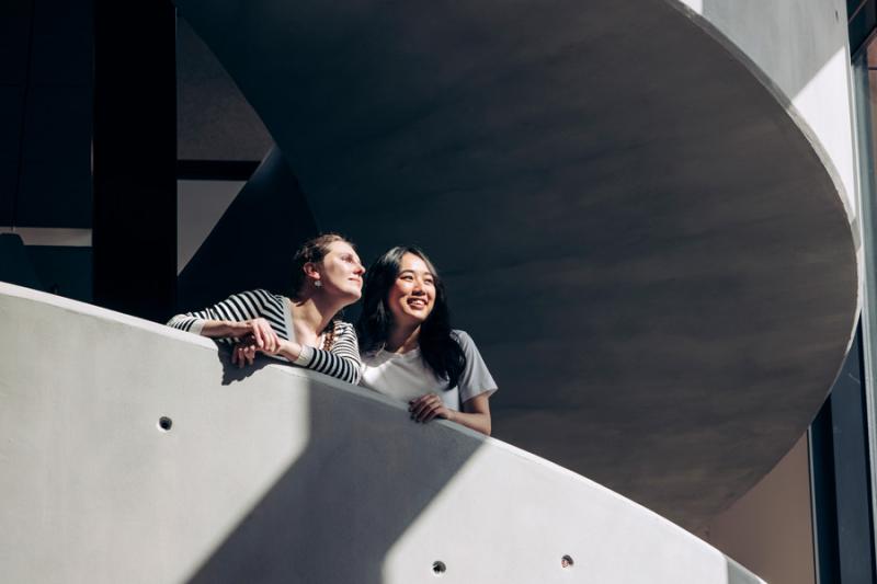 Two students looking from a staircase