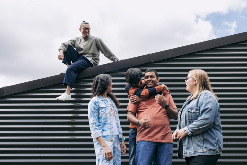 A group of students posing in front of a wall