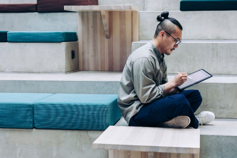 Student reading while sitting on a staircase