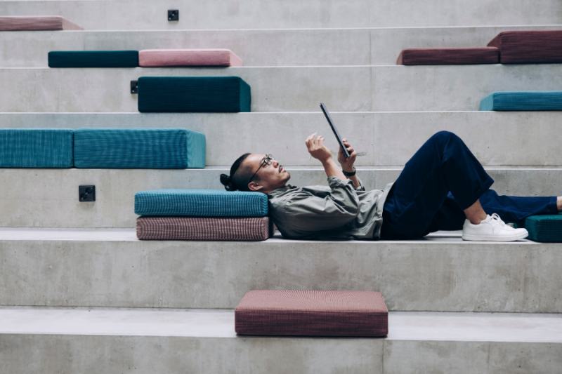 Student reading at a staircase